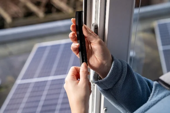 Hände bringen Dichtung an Fenster an